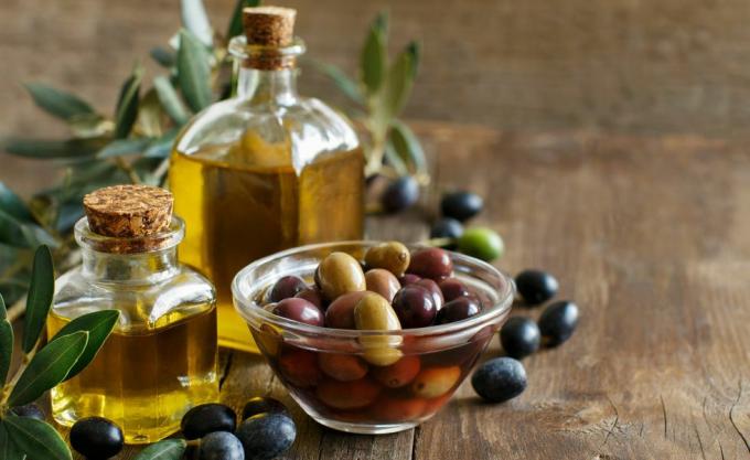 Зехтин и маслини на дървен фон