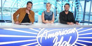 Лайънъл Ричи, Кейти Пери и Люк Брайън седят на бюро с логото на American Idol отпред