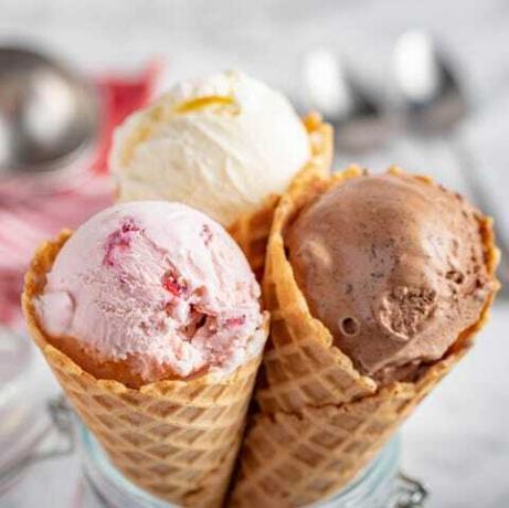 ягодов, ванилов, шоколадов сладолед с вафлена фунийка върху мраморен каменен фон