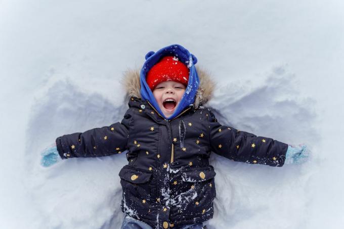 малко дете в сняг, което прави снежен ангел